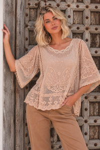 Butterfly Lace Top in Blush, close-up on model showing butterfly embroidery, rounded neckline and scalloped lace edges.