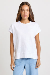 Betty Basics Shirley Short Sleeve Tee in White — full-length front view of relaxed cotton slub tee with crew neckline, rolled cuffs and high-low hem, styled with light blue wide-leg jeans.