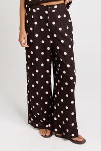 Front view of the Betty Basics Zander Pant in chocolate with pink polka dots, showing the waistband and full-length wide legs.