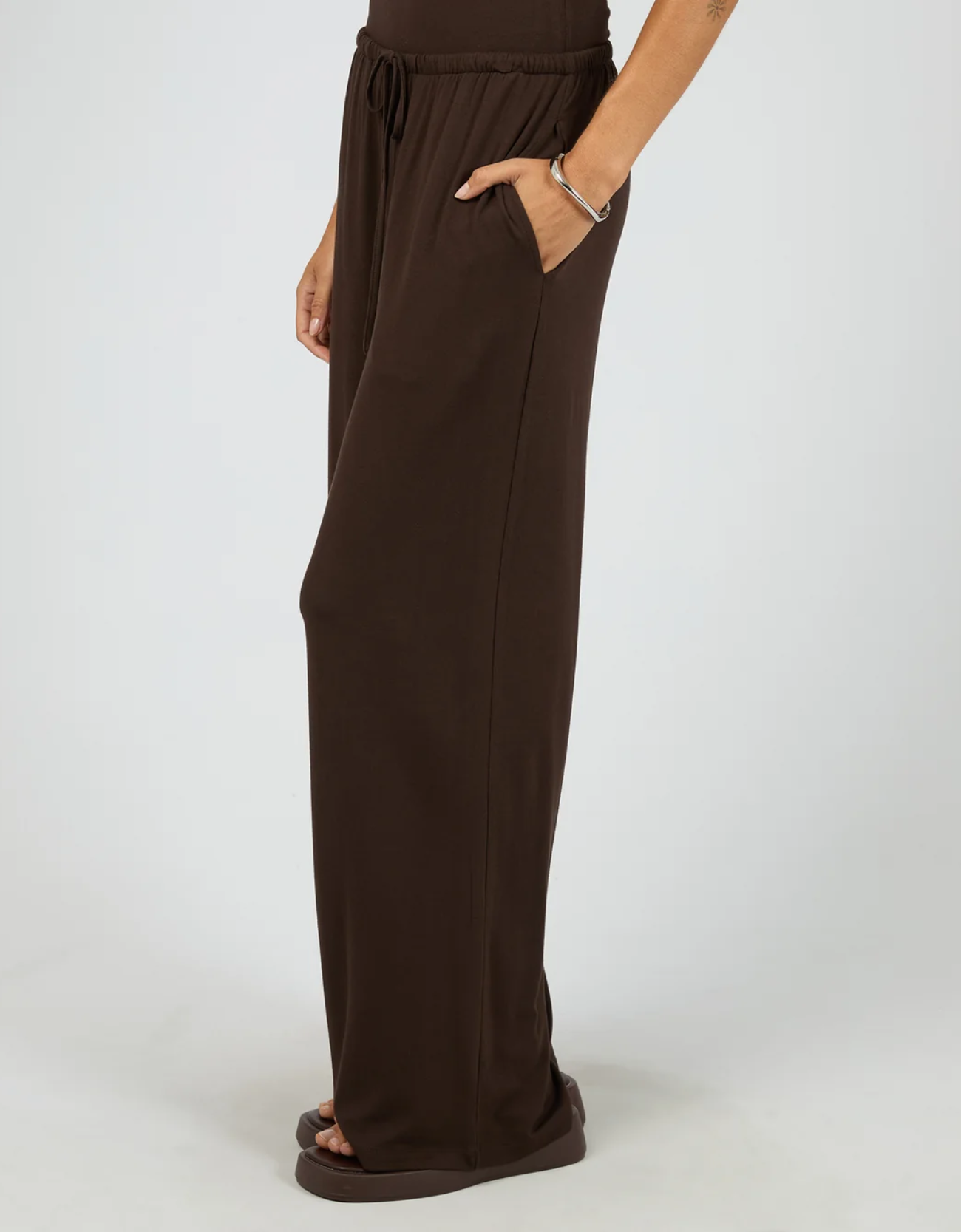 Silent Theory Dara Pant in Chocolate – side profile view highlighting deep side seam pocket, elastic drawstring waist and flattering wide-leg silhouette in soft chocolate viscose-elastane blend