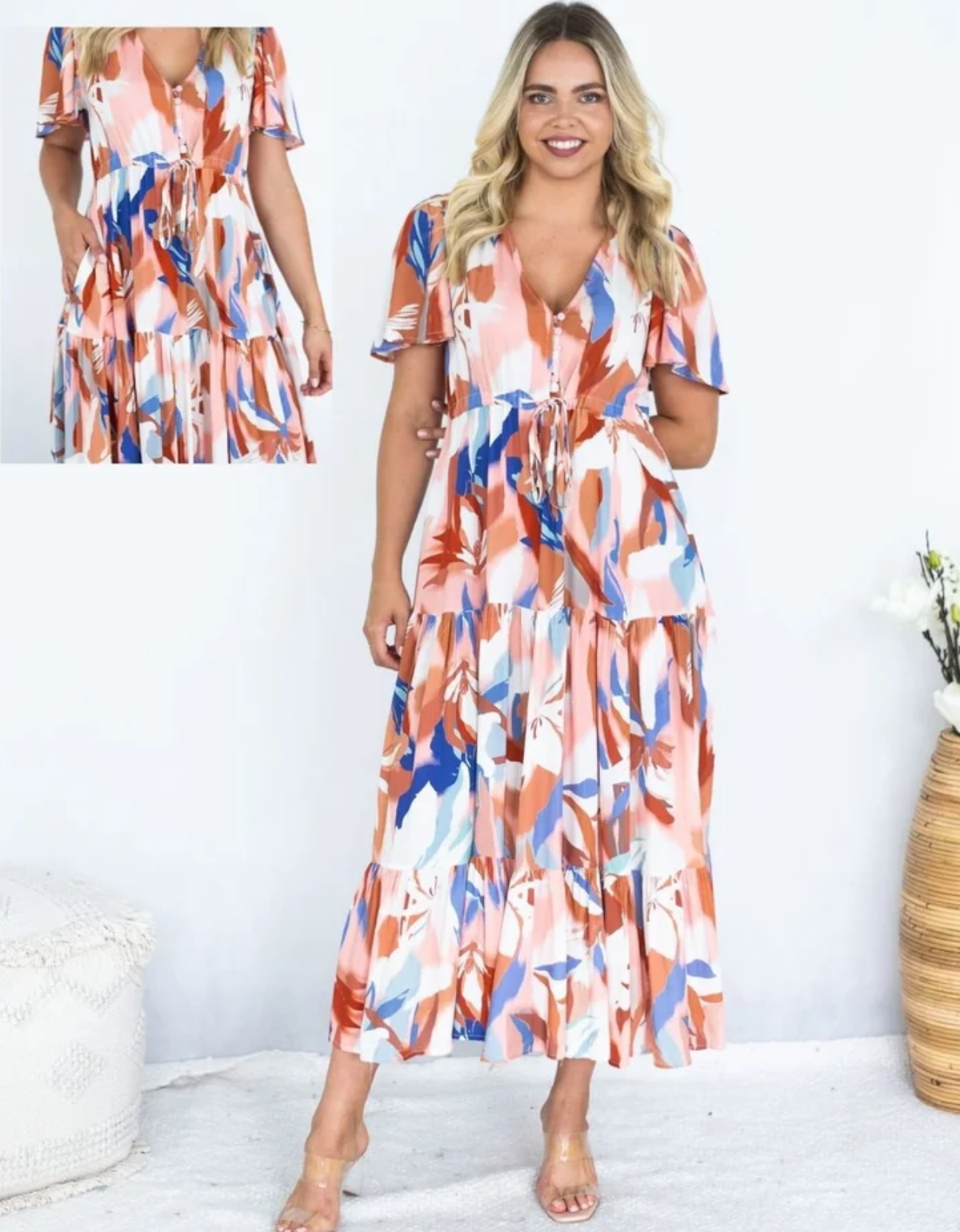 Fria The Label Selma Maxi Dress in peach, rust and blue Canvas Bloom print, with flutter sleeves and a tiered skirt, plus an inset waist detail.