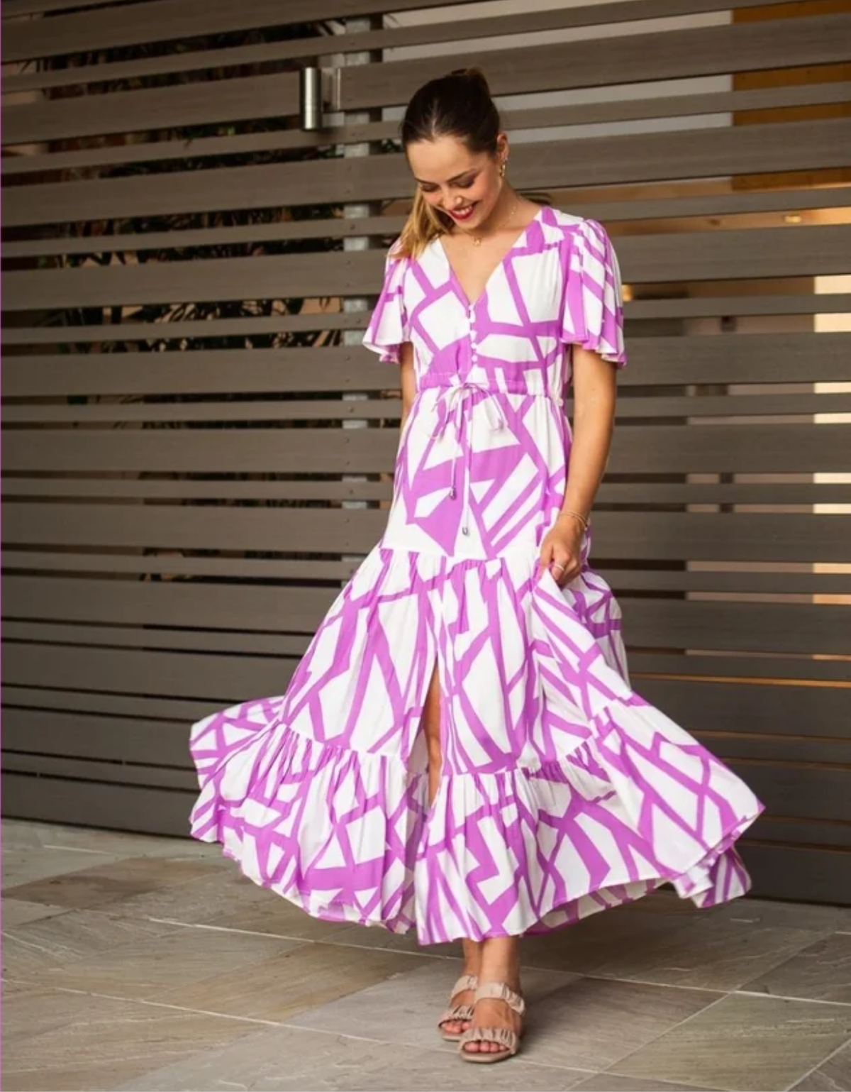Fria The Label Selma Maxi Dress in lilac and white geometric print, showing flutter sleeves, a drawstring waist and flowing tiered skirt.