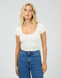 All About Eve Washed Rib Lace Scoop Neck Tee Vintage White - model close up front view showing lace trim scoop neckline and cap sleeve lace edge detail with blue jeans