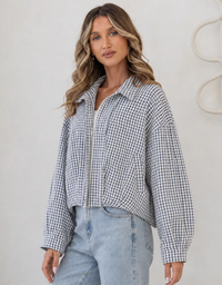 Model wearing the Smaibulun Sloane Gingham Bomber Jacket in Navy Check with light blue jeans, showing its relaxed fit.
