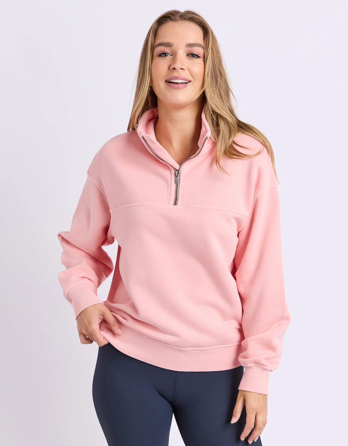 Foxwood College Pigment Zip Crew in Peach, front view on model showing the zip collar, long sleeves and relaxed fit.