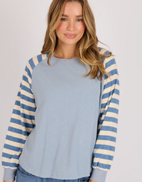 Model wearing the One Ten Willow long sleeve raglan top in blue stripe with a relaxed fit.