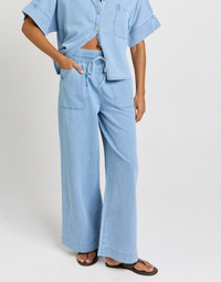 Model wearing Betty Basics Saffra Relax Leg Jean in medium wash with a relaxed fit and mid-high rise