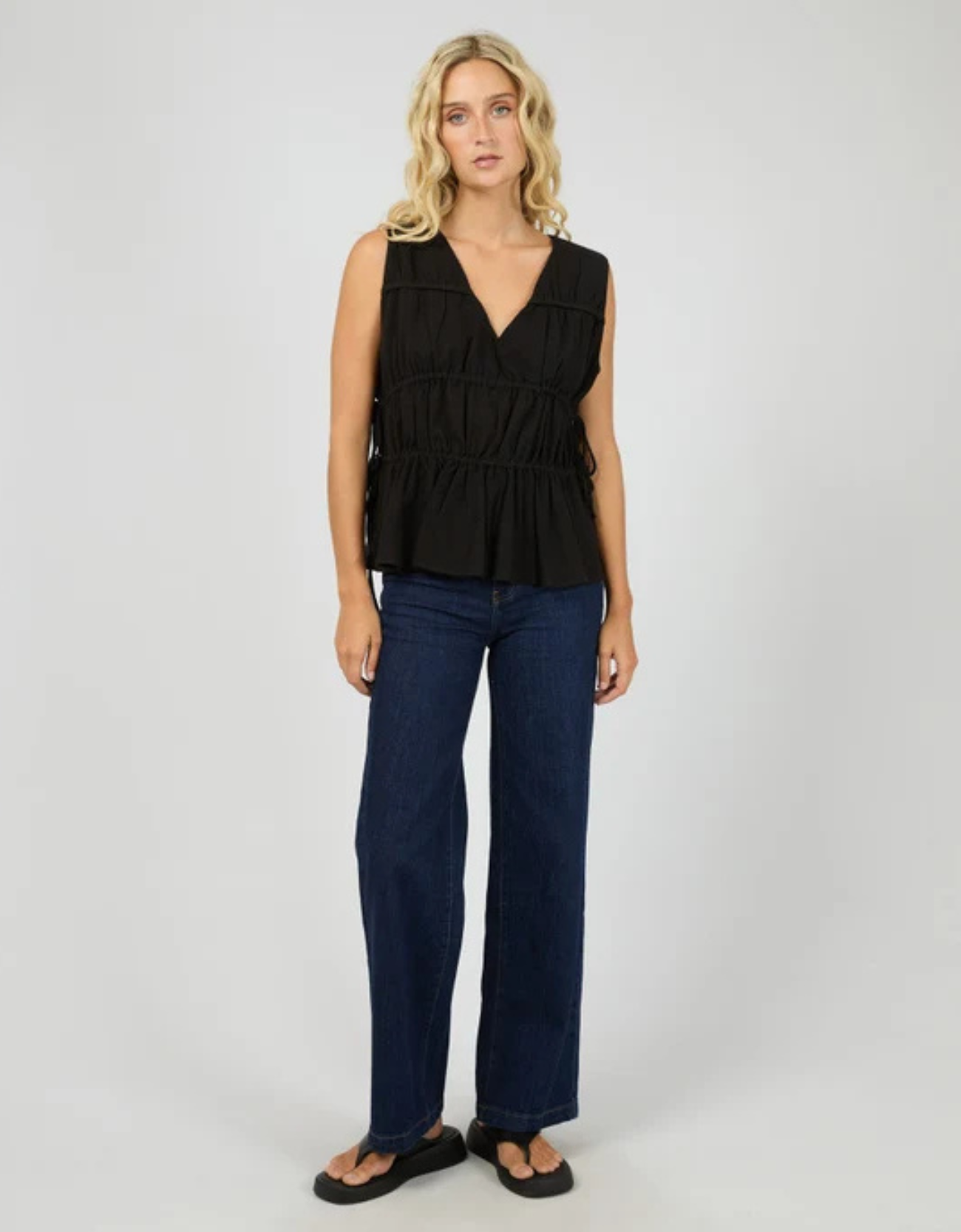 All About Eve Heidi Ruched Top in Black — side view showing ruching and peplum hem

