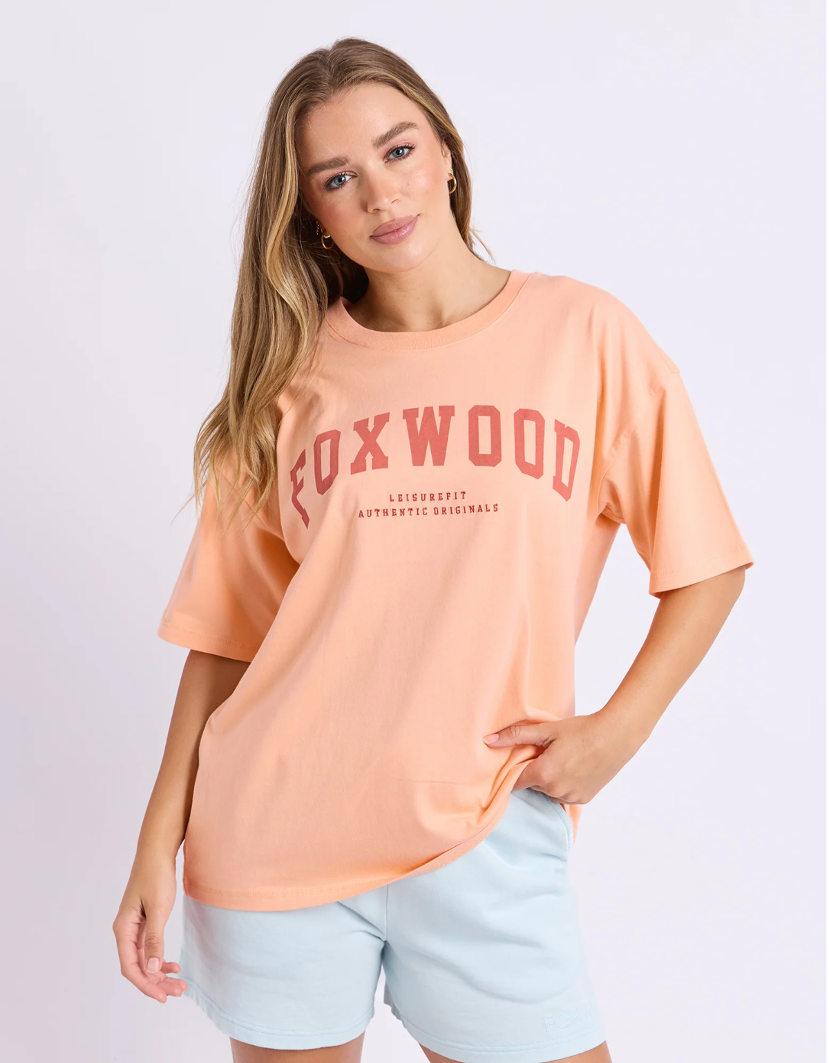 Foxwood Interval Tee in peach with coral Foxwood chest lettering, a crew neckline, dropped shoulders and relaxed short sleeves.