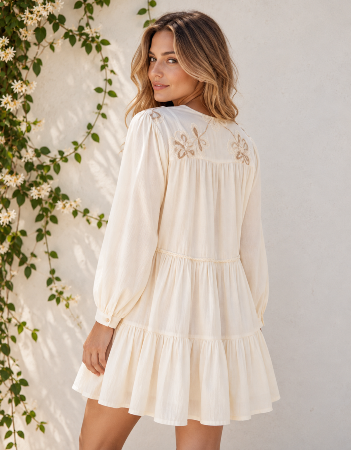 Back view of the Smaibulun ivory boho dress, showing floral embroidery across the back yoke, gathered detailing and a tiered skirt.