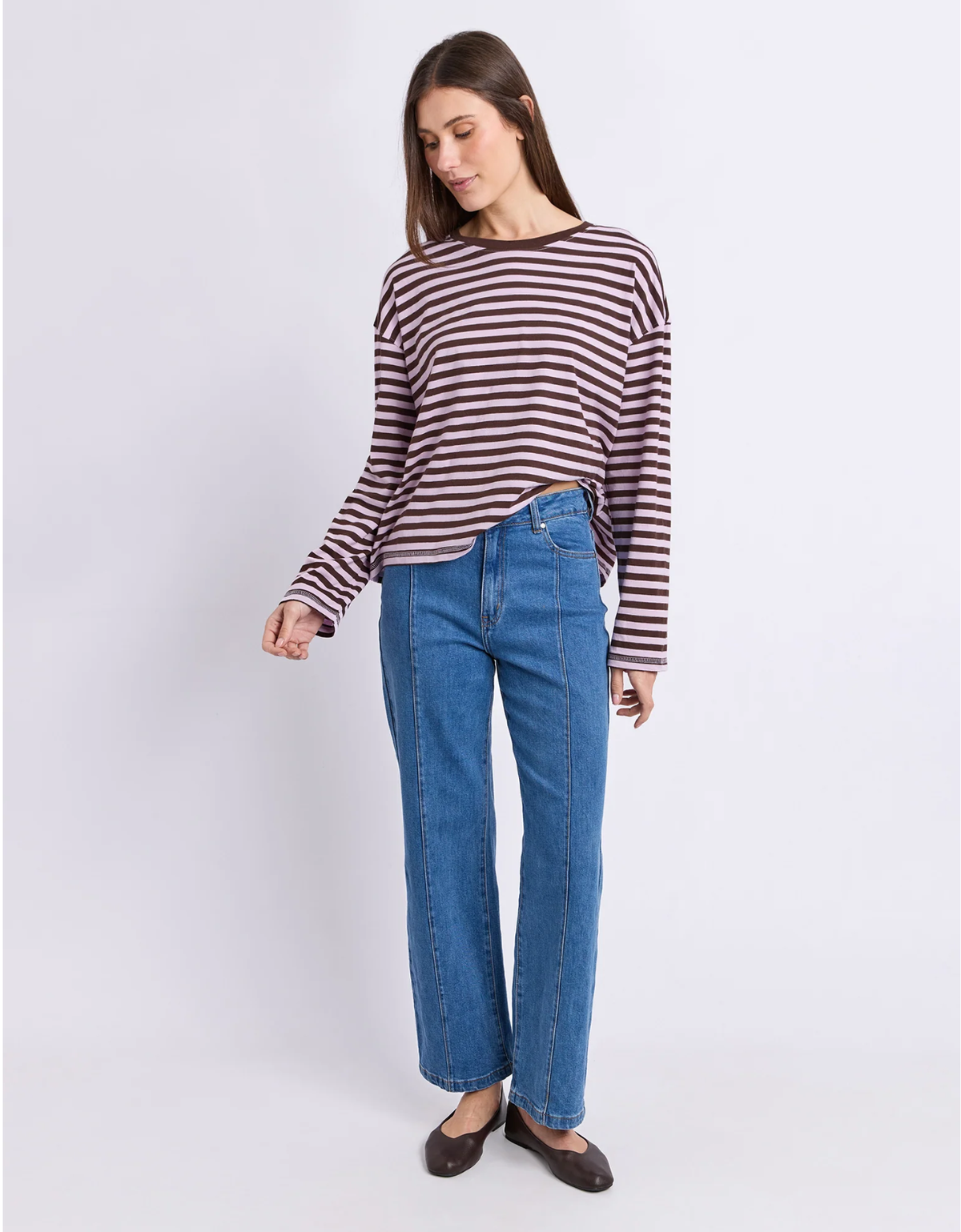 Model wearing the Foxwood Lola Stripe Long Sleeve in lilac and chocolate with blue jeans and brown flats.