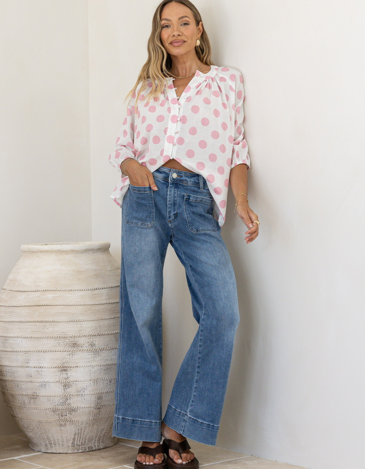 Country Denim Winnie Wide Leg Jean in Mid Blue — full length front view styled with pink polka dot blouse and brown sandals, showcasing front patch pockets and contrast hem band