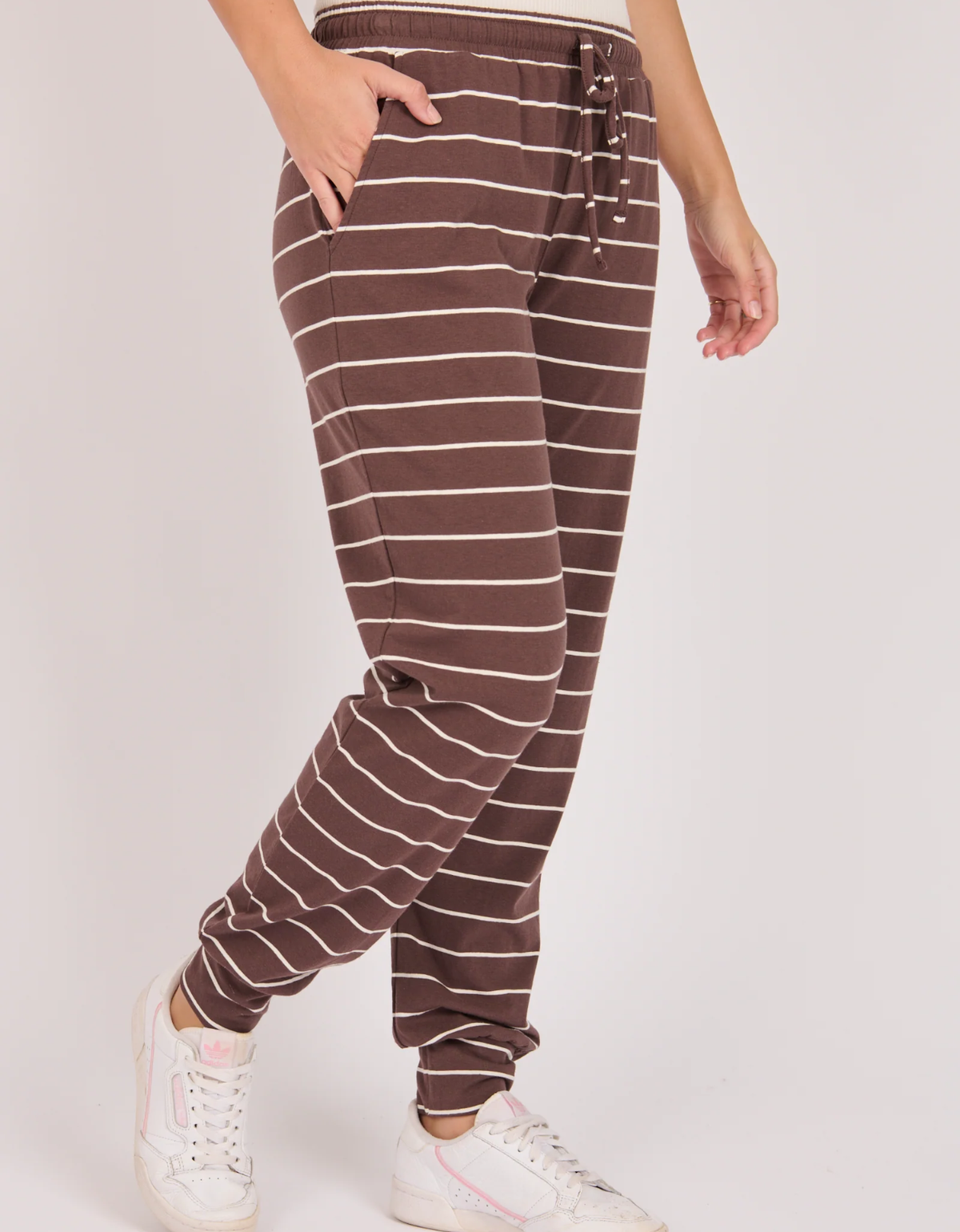 Model wearing the One Ten Willow Everyday Pant in Chocolate/Ecru Stripe with an elasticated waist close up side view